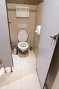 Classic toilet cubicle with open door in a public restroom