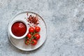 Classic tomato sauce with spices on a concrete background. View from above