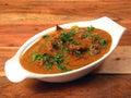 Classic Traditional Indian Lamb Dish, Mutton Rogan Josh served over a rustic wooden background, selective focus