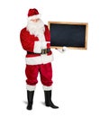 Classic traditional red santa claus holding empty wooden slate blackboard chalkboark pointing with finger on it. blank slate with Royalty Free Stock Photo