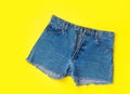 Classic Trendy Women Jeans Denim Shorts with Fringes on Bright Yellow Background. Flat Lay. Street Summer Fashion Sale Lifestyle Royalty Free Stock Photo