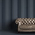 Classic tufted sofa in gray empty room with relief stripe wall