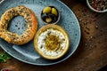 Classic Turkish breakfast - simit with feta cheese mousse with olive oil and spices, served on blue plate with olives. Wood Royalty Free Stock Photo