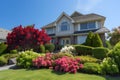 classic two-storey house with flower garden at sunny summer day - american dream style, neural network generated image Royalty Free Stock Photo