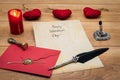 Classic Valentine`s Day cad with decorative quill and stand, red envelop with wax seal, red candle and cuddle, space for your text Royalty Free Stock Photo