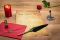 Classic Valentine`s Day cad with decorative quill and stand, red envelop with wax seal, red candle and rose, space for your text Royalty Free Stock Photo