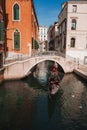 Classic Venetian Gondola on Vibrant Green Canal with Traditional Architecture in Venice, Italy