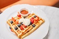 Classic Viennese waffles with ice cream, berries and Maple syrup. Breakfast in cafe. Table in the restaurant. Royalty Free Stock Photo