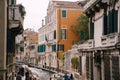 Classic view of the narrow sea Venetian canal. Colorful buildings stand opposite each other, boats moored near shore