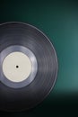 Classic vinyl record close-up on a green background, obsolete data storage, music Royalty Free Stock Photo