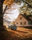 A classic Volkswagen van parked below a cabin in Pomfret, Vermont in the height of Autumn.