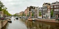 A classic water canal in Amsterdam, view from the bridge on the Dutch city buildings