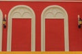 Classic white arch door pattern on the red wall background. Royalty Free Stock Photo