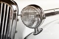 Classic white car in front view with detail on vintage style headlamp Royalty Free Stock Photo