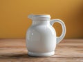 Elegant White Ceramic Jug on Wooden Table with Warm Yellow Background Ideal for Kitchen Decor, Home Interiors, and Artistic Still Royalty Free Stock Photo