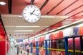 A classic white digital clock and escape exit sign hang from the ceiling of the modern subway station Royalty Free Stock Photo