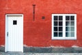 a white door and window in a red wall with grey and black accents Royalty Free Stock Photo