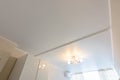 Classic white matte stretch ceiling with separation for curtains in two halves