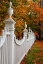 A classic white picket fence with an autumn scene Royalty Free Stock Photo