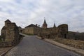 Classic wide-angle landscape view of cobble stone road to the ancient Kamianets-Podilskyi Castle against cloudy winter sky. Royalty Free Stock Photo