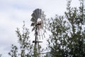 Classic windmill against trees and cloudy day background