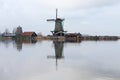 A CLASSIC WINDMILL REFLECTING AT THE CALM WATERS OF ZAANSE SCHANS