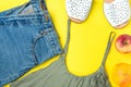 Classic Women Jeans Denim Shorts with Fringes Olive Color Tank Top Espandrille Sandals Apple Grapefruit on Yellow Background