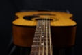 Classic wooden acoustic guitar closeup, on a black background, rock, country music concept Royalty Free Stock Photo