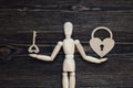 Classic wooden dummy holds heart-lock and key. Royalty Free Stock Photo