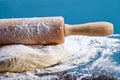 Classic wooden rolling pin with freshly prepared dough and dusting of flour on black background Royalty Free Stock Photo