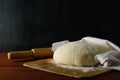 Classic wooden rolling pin with freshly prepared dough and dusting of flour on wooden background Royalty Free Stock Photo