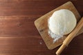 Classic wooden rolling pin with freshly prepared dough and dusting of flour on wooden background Royalty Free Stock Photo