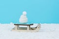 Classic wooden sled and knitted hat on snow on a blue background Royalty Free Stock Photo