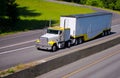 Classic working heavy semi truck with bulk trailer on highway ne Royalty Free Stock Photo
