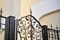 A classic yellow house and a beautiful iron fence with a gate