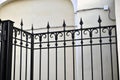 A classic yellow house and a beautiful iron fence with a gate