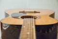 Classical acoustic guitar Detail of an acoustic guitar behind a white background vibrating strings