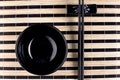 Classical asian chopsticks and bowls at bamboo mat