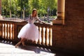 Classical ballet dancer dressed in a white tutu leaning on the railing of a park doing a beautiful ballet pose. Classical ballet Royalty Free Stock Photo