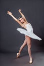 Classical Ballet dancer portrait. Beautiful graceful ballerina in white tutu from Swan lake practices releve ballet position in Royalty Free Stock Photo