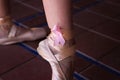 Classical Ballet Dancer`s Feet On Points. On The Bow Of The Shoes You Can See A Pink Ribbon In Solidarity With Breast Cancer.