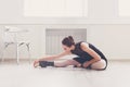 Classical ballet dancer stretching in white training class Royalty Free Stock Photo