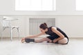 Classical ballet dancer stretching in white training class Royalty Free Stock Photo