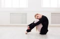 Classical ballet dancer stretching in white training class Royalty Free Stock Photo