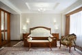 Classical bedroom with a large double bed, bedside tables, chairs