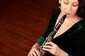 Classical culture. A beautiful clarinetist sitting and playing her instrument - copyspace.