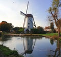 A classical dutch view with a windmill reflecting in a small pond Royalty Free Stock Photo