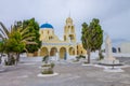 Classical Greek Orthodox church in OÃÂ­a, Santorini island. Beautiful yellow church with blue dome in a square in cloudy day.