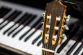 classical guitar against grand piano keys - musical instruments closeup - Spanish guitar with nylon strings for classical music