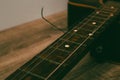 Classical guitar with broken string. Closeup of classical acoustic wooden guitar with a broken string Royalty Free Stock Photo